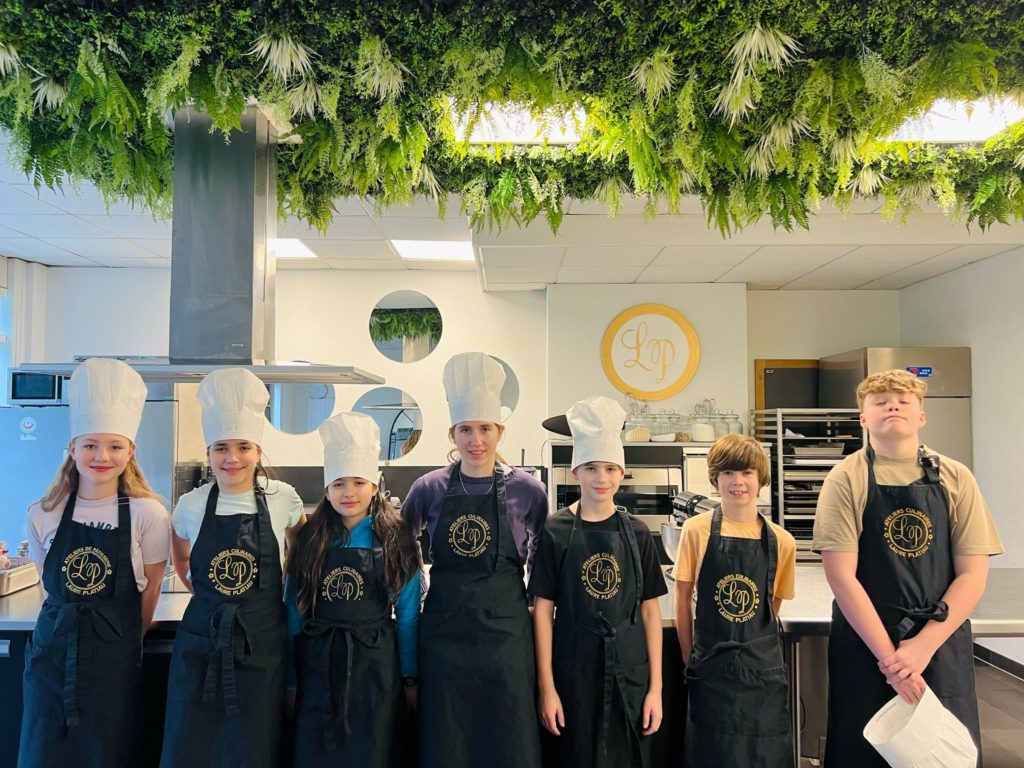 cette photo montre des enfants en tabliers de cuisine lors d'une activité pour enfant à genève
