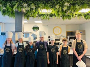 cette photo montre des enfants en tabliers de cuisine lors d'une activité pour enfant à genève
