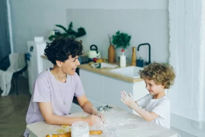 cette image montre un enfant qui cuisine avec sa mère